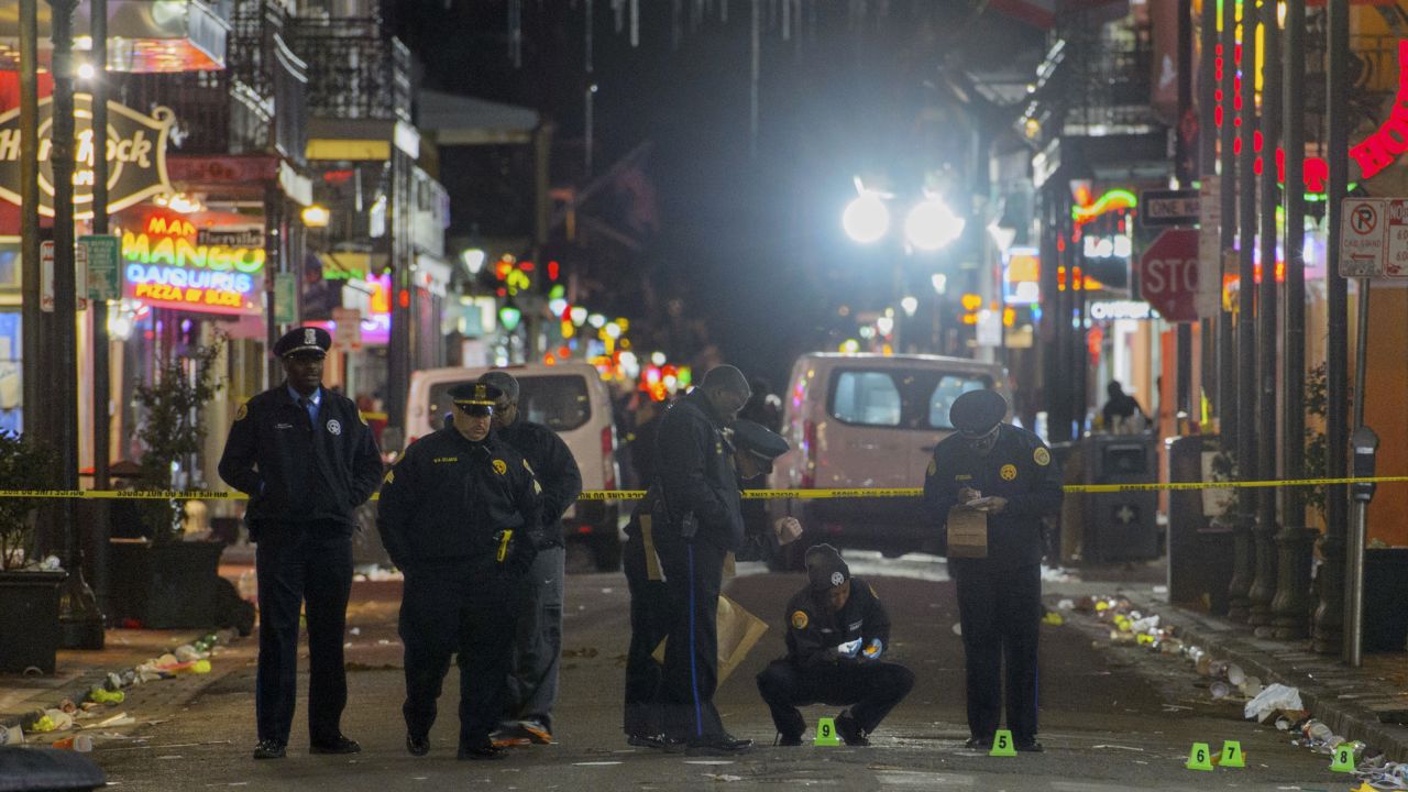 New Orleans Police Department investigators study a crime scene after a fatal shooting in New Orleans, Sunday, November. 27, 2016. 