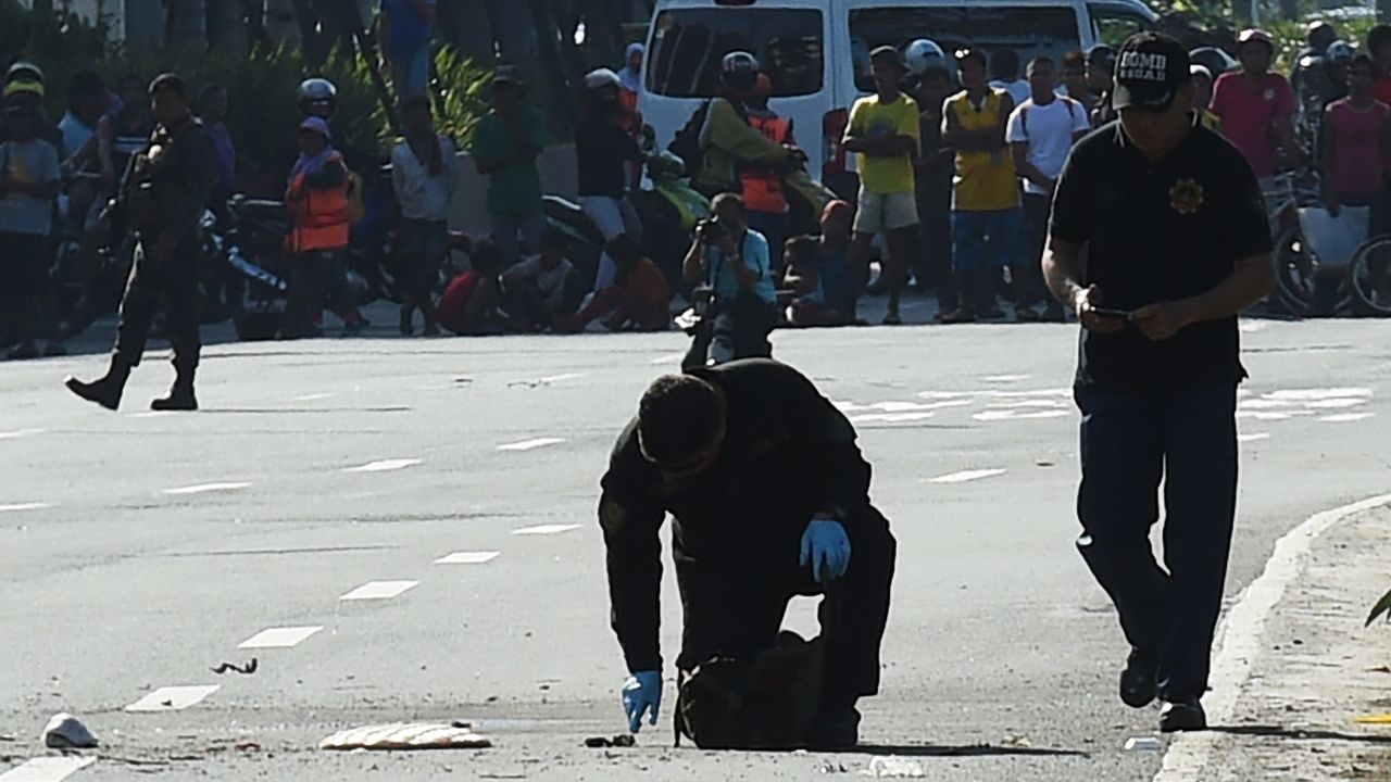 Bomb disposal officers inspect an improvised explosive device in Manila on November 28. 