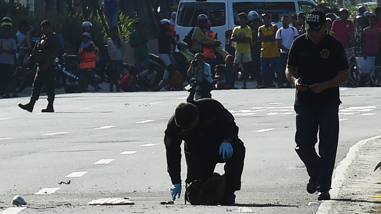Bomb disposal officers inspect an improvised explosive device in Manila on November 28.