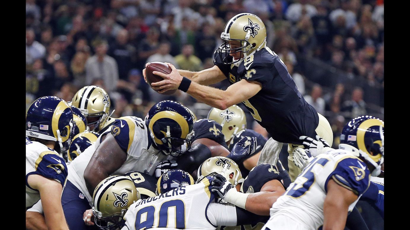 New Orleans quarterback Drew Brees dives over the pile for a first-half touchdown against Los Angeles on Sunday, November 27. Brees also threw four touchdowns in the 49-21 victory.