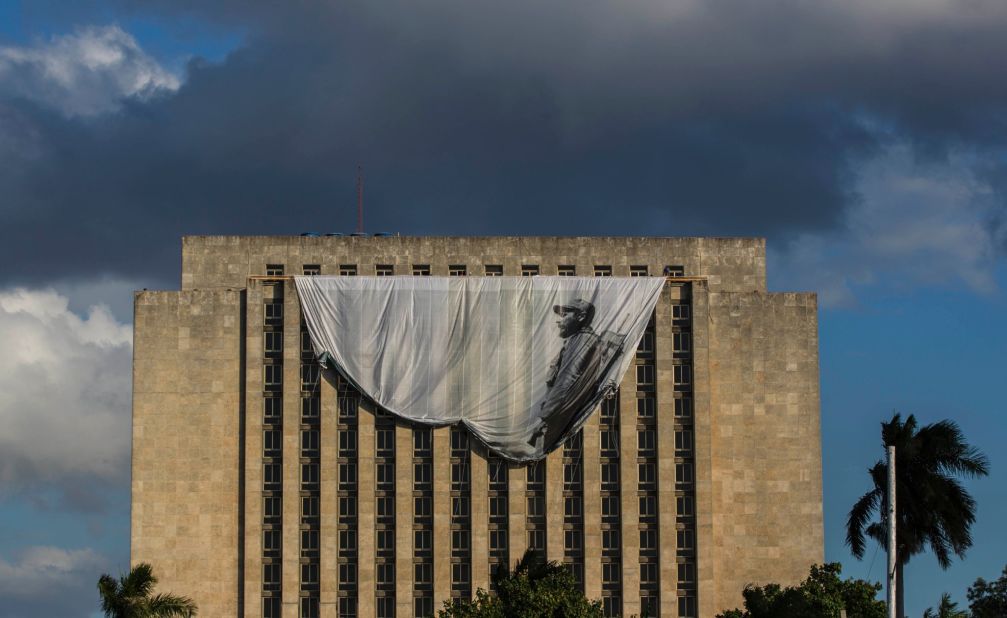 Workers hang a giant banner of a young Castro from the Cuban National Library in Havana on Sunday, November 27. 