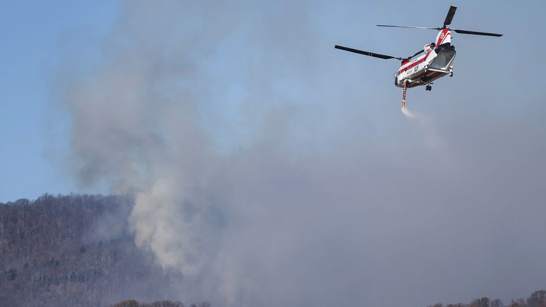 A helicopter picks up water from Thrasher Lake to help battle a wildfire in Amherst County, Virginia, on November 21.