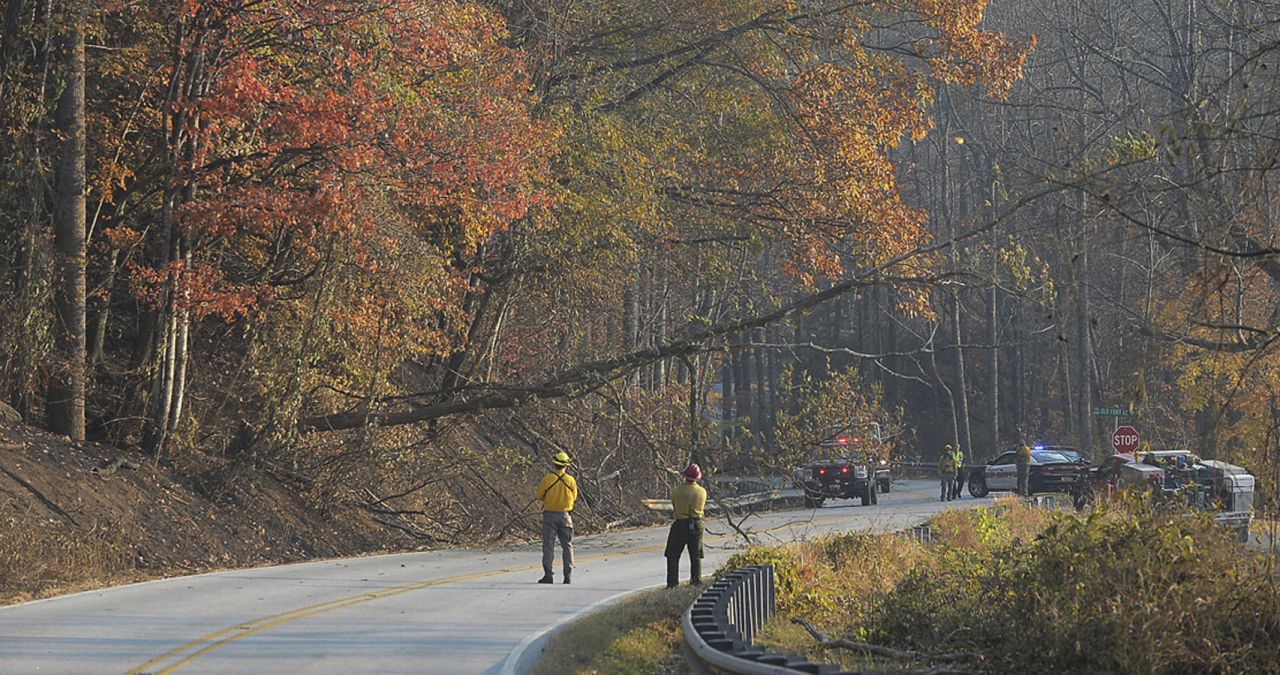 Fire crews bring down a dead tree along Highway 9 near the community of Bat Cave, North Carolina, on Friday, November 18.