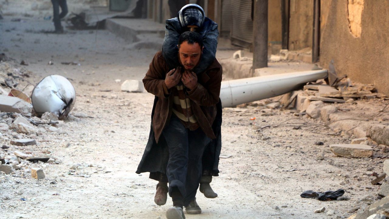 A man helps evacuate a wounded victim after airstrikes in al-Shear, Aleppo, on Monday.