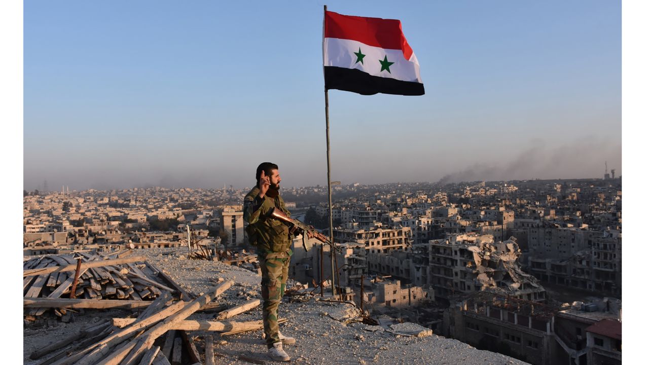 A pro-government soldier looks over the city of Aleppo on Monday.
