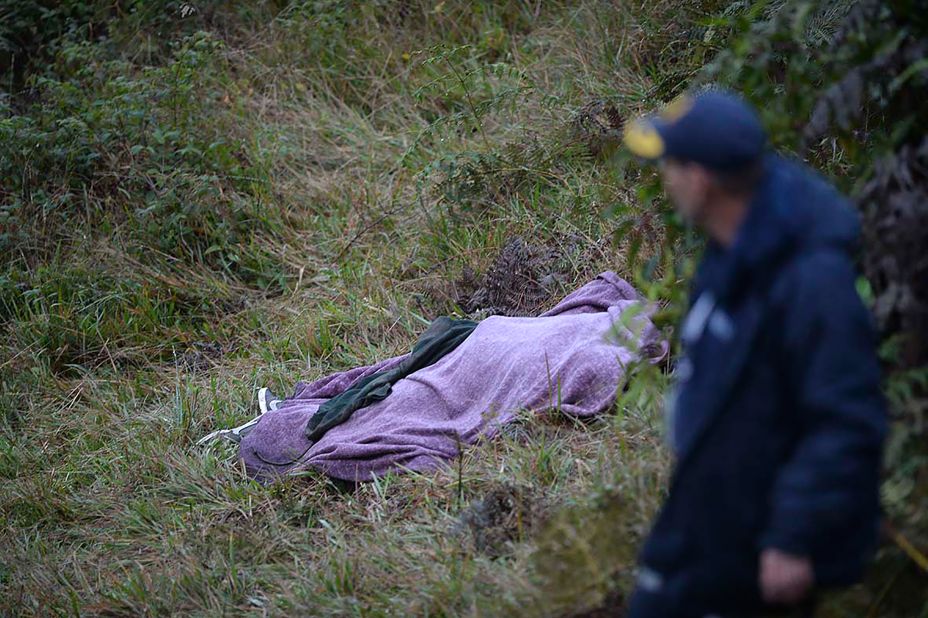A rescuer walks past a victim's body on Tuesday, November 29.