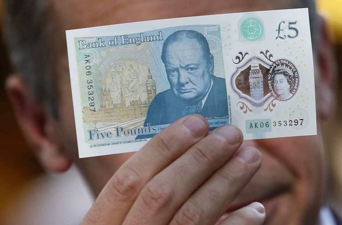 Mark Carney, governor of the Bank of England, poses with a new polymer five-pound note 