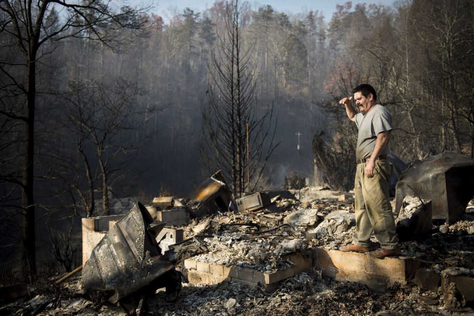 Polo Gutierrez climbs onto the foundation of a destroyed home to try to see if his apartment building is still standing in Gatlinburg on November 29. Gutierrez fled his apartment with other residents as fires approached the previous night. 