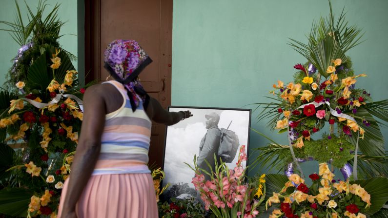 A woman stretches her hand toward a picture of Castro at a memorial in Guanabacoa, on the outskirts of Havana, on November 29.