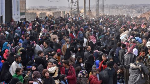 Syrians fleeing from eastern Aleppo line up to board government buses on Tuesday.