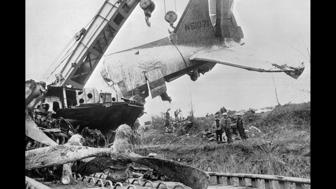 Workers watch as a large crane swings the tail section of a wrecked DC-3 onto a flatbed car at Dress Regional Airport in Evansville, Indiana, on December 16, 1977.