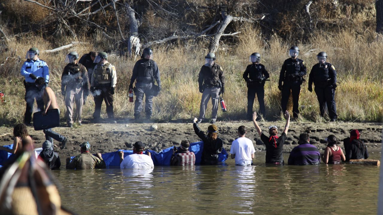 Dozens of protesters wade in cold creek waters as they confront local police on November 2.