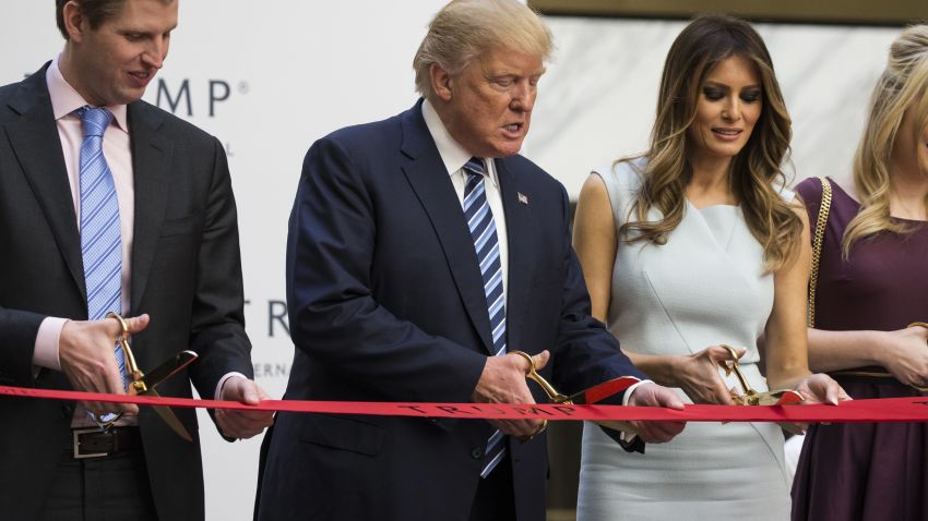 WASHINGTON, USA - October 26: Republican Presidential Candidate Donald Trump (C) cuts the ribbon with his son, Eric Trump (L), and wife, Melania Trump (R), during opening ceremony for the Trump International Hotel, Old Post Office, in Washington, USA on October 26, 2016. (Photo by Samuel Corum/Anadolu Agency/Getty Images)