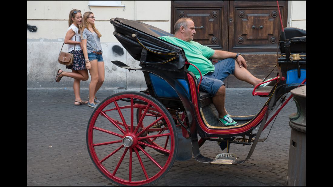 The owner of a horse-drawn carriage waits for customers.