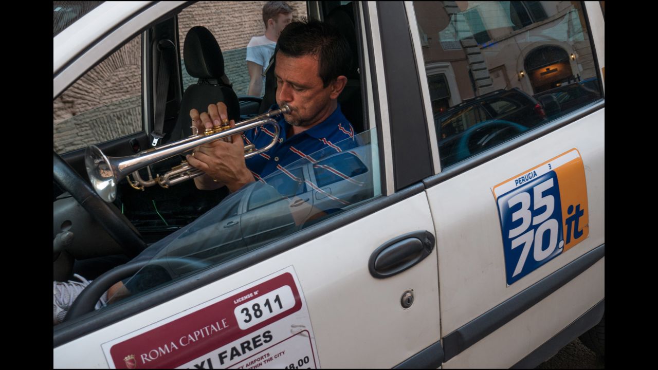 This taxi driver practices on his trumpet.