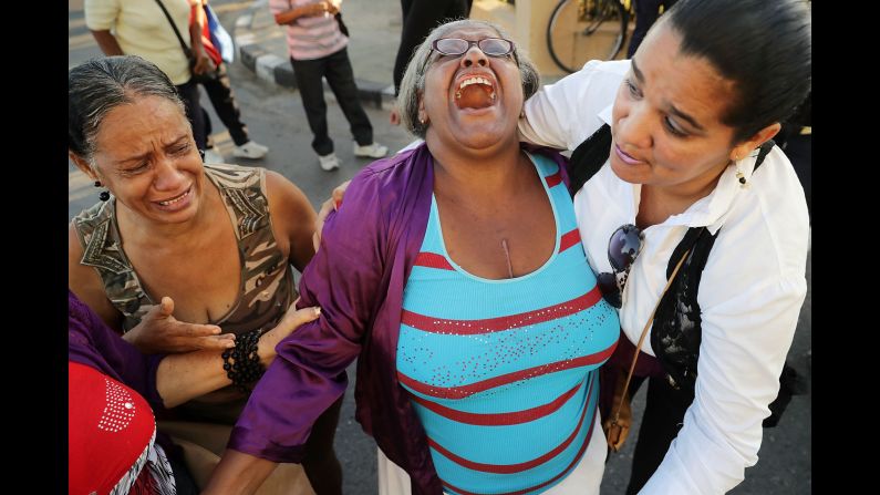 Women comfort one another after watching Castro's remains pass by in Havana on November 30.