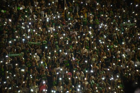 Fans of the team hold their cell phones in the air during the tribute.