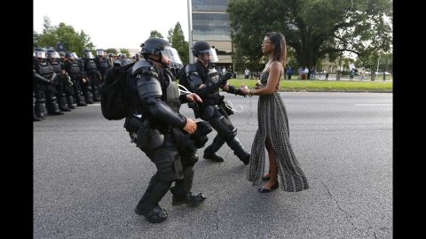 <strong>July 9:</strong> A young woman stands in the street as two police officers move in to arrest her near the headquarters of the Baton Rouge Police Department in Louisiana. She was one of hundreds of protesters <a href="http://www.cnn.com/2016/07/09/us/black-lives-matter-protests/" target="_blank">who blocked a Baton Rouge roadway</a> to decry police brutality.