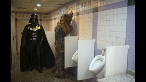 <strong>October 17: </strong>Fans dressed as "Star Wars" characters Darth Vader and Chewbacca use the bathroom during a film festival in Antalya, Turkey.