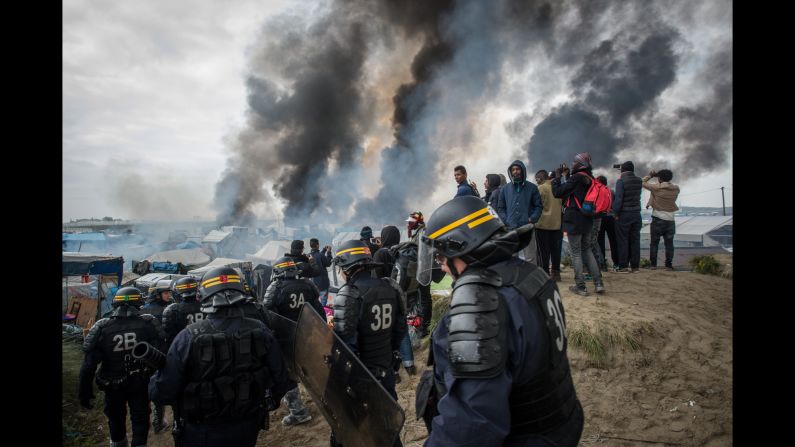 <strong>October 26:</strong> Smoke rises from <a href="http://www.cnn.com/2016/09/26/europe/gallery/the-saga-of-the-calais-jungle/index.html" target="_blank">"The Jungle,"</a> a makeshift migrant camp in Calais, France, that authorities <a href="http://www.cnn.com/2016/10/26/europe/calais-jungle-france-close/" target="_blank">began dismantling</a> on October 24. During evacuations, some of the migrants set shelters on fire. By the middle of the week, more than 4,400 people had been bused out of Calais to other regions of the country. The town is known for being a major transit point for migrants trying to reach Great Britain.