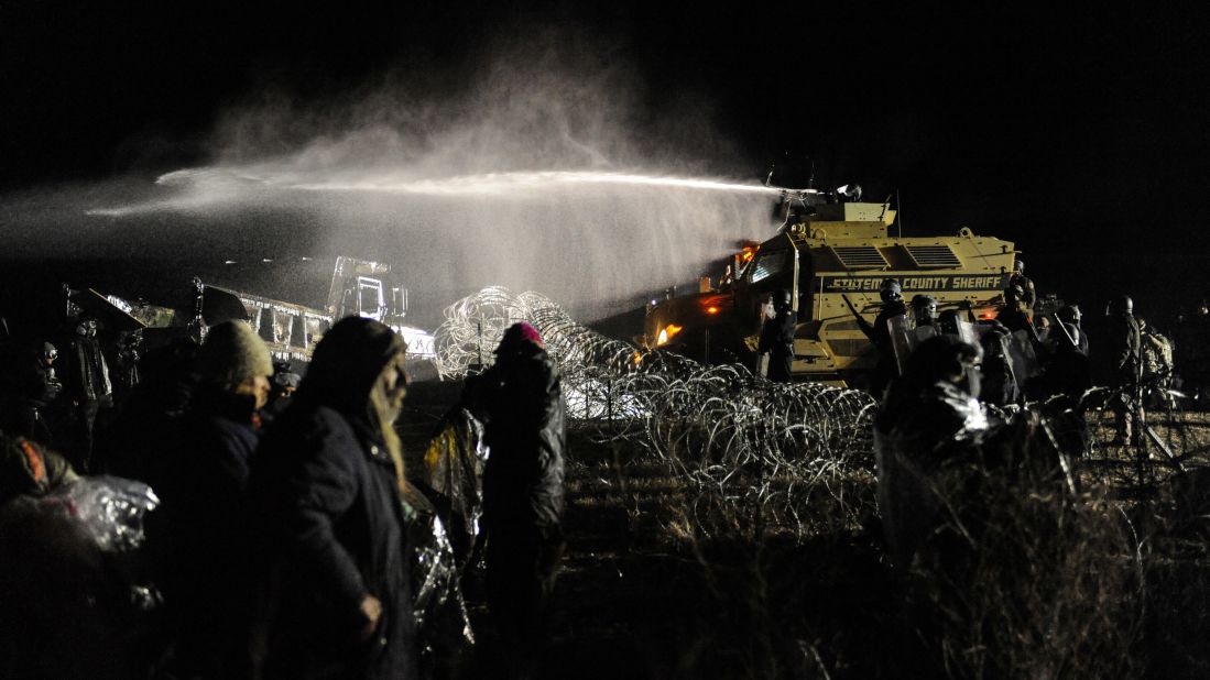 <strong>November 20:</strong> Police use a water cannon on people protesting the Dakota Access Pipeline near Cannon Ball, North Dakota. The <a href="http://www.cnn.com/2016/09/07/us/dakota-access-pipeline-visual-guide/" target="_blank">Dakota Access Pipeline</a> is a $3.7 billion project that would cross four states and change the landscape of the US crude oil supply. But the Standing Rock Sioux tribe says the pipeline would affect its drinking-water supply and destroy its sacred sites.