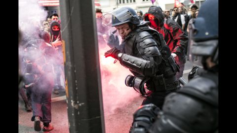 <strong>April 28:</strong> A police officer reacts during a clash with protesters in Lyon, France. People were protesting proposed reforms to the country's labor laws, and strikes forced cancellations and delays at two airports serving Paris.