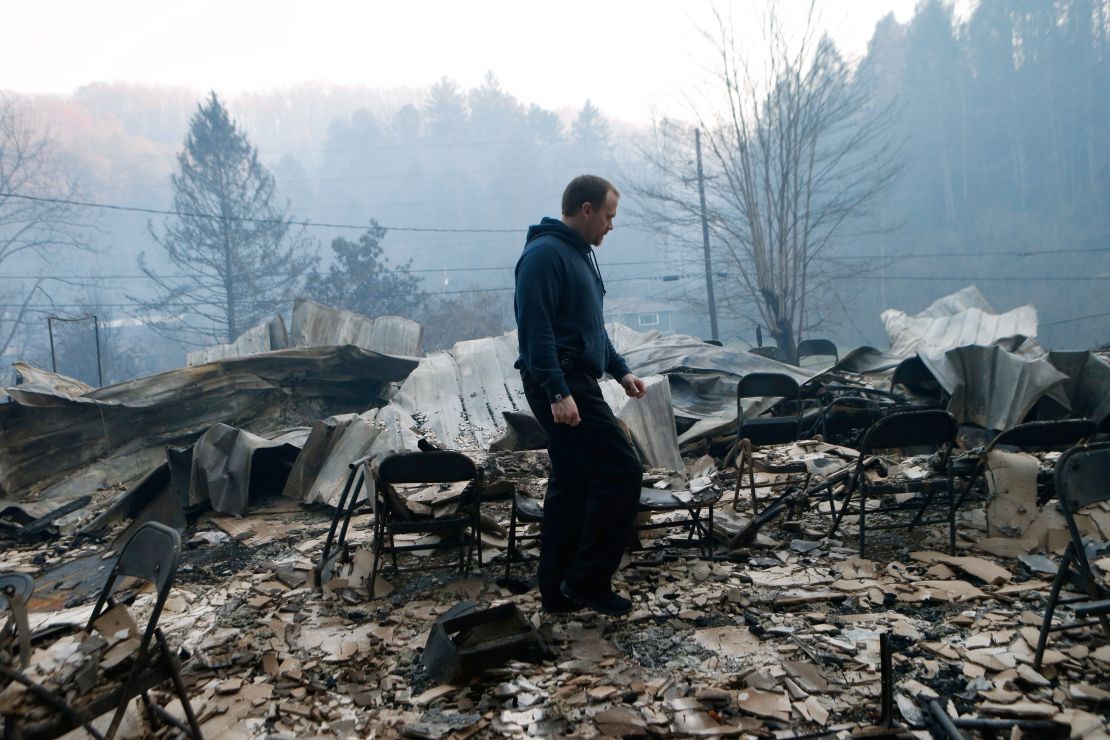 Trevor Cates walks through the smoldering remains of the fellowship hall of his church, the Banner Baptist Church, in Gatlinburg on Tuesday.