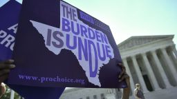 An abortion rights activist holds placards outside of the US Supreme Court before the Court struck down a Texas law placing restrictions on abortion clinics on June 27, 2016 in Washington, DC.