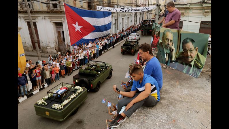 People watch from a rooftop as Castro's remains pass by in Santa Clara on December 1. Castro's ashes are on a four-day journey from Havana to Santiago de Cuba.