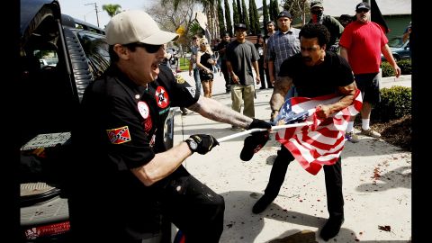 <strong>February 27:</strong> A member of the Ku Klux Klan fights a man for an American flag during a KKK rally in Anaheim, California. <a href="http://www.cnn.com/2016/02/27/us/kkk-rally-in-anaheim-violence/" target="_blank">Violence broke out</a> between KKK members and counterprotesters, leaving five people injured and 13 people arrested, authorities said.