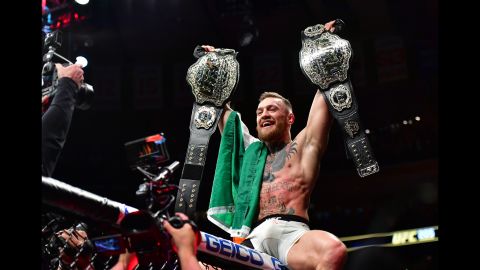 UFC fighter Conor McGregor celebrates with two championship belts after knocking out Eddie Alvarez in New York on Sunday, November 13. McGregor was the featherweight champion coming into the bout, and his victory over Alvarez gave him the lightweight title. He is the first fighter in UFC history to hold two titles simultaneously.