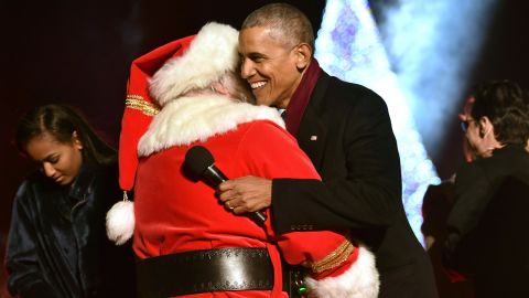 President Barack Obama hugs and a man dressed as Santa Claus during the National Christmas Tree Lighting on the Ellipse of the National Mall in Washington on December 1, 2016.