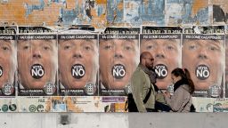 People walk past posters for far-right political movement CasaPound, which is calling for a vote "No" in Italy's constitutional referendum.