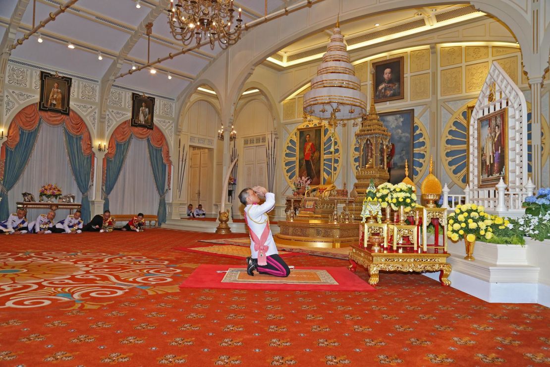 Vajiralongkorn kneels before a portrait of his parents after being confirmed as King. 