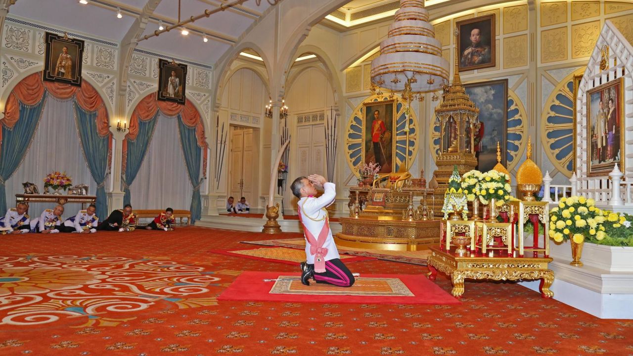 Vajiralongkorn kneels before a portrait of his parents after being confirmed as King.
