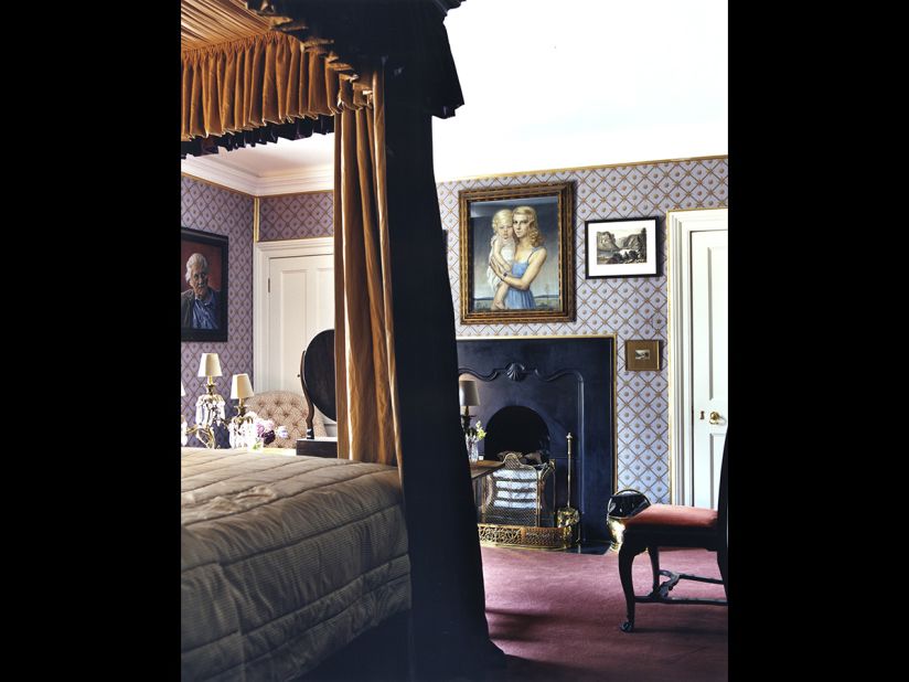 A Victorian bed hung with purple silk is the centerpiece of a guest bedroom in Luggala. According to the book, "it takes the Honourable Garech Browne about twenty minutes to drive to the nearest village, but most of that time is spent exiting his own property."
