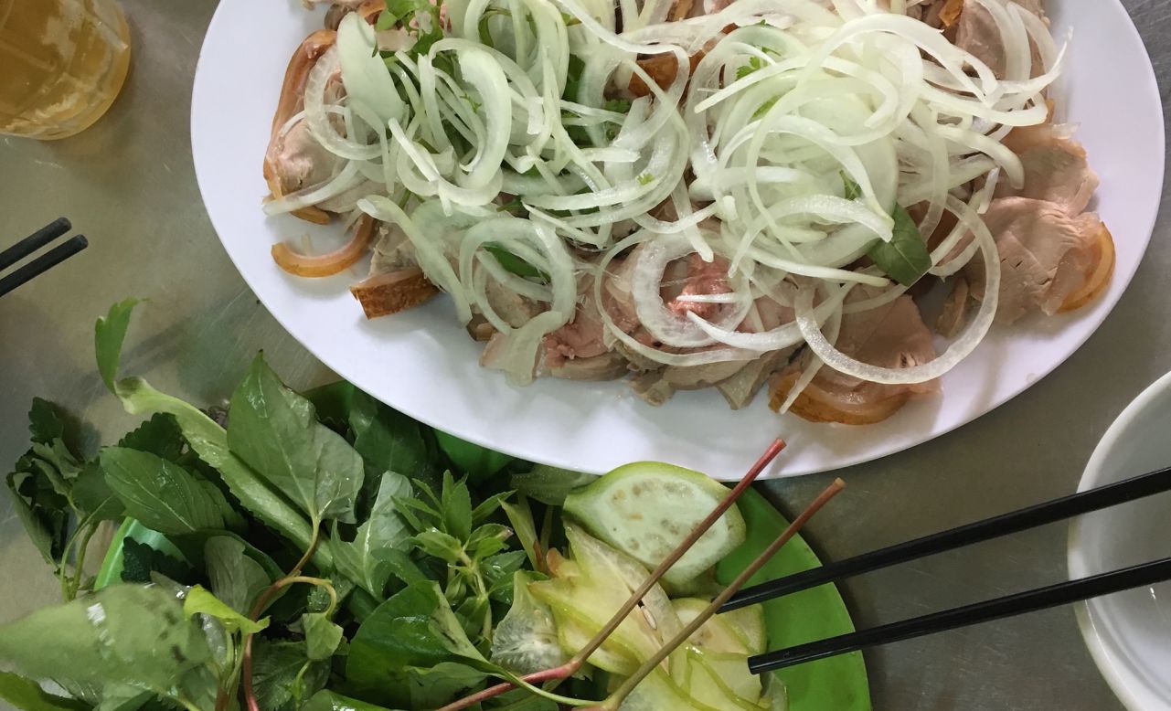 This celebratory dish is made by roasting a whole veal calf until the skin is blackened. Cut into thin slices and served with pickled onions, be thui can be eaten with Vietnamese coriander, sliced starfruit and green banana, all wrapped in rice paper and dipped in fermented shrimp paste.