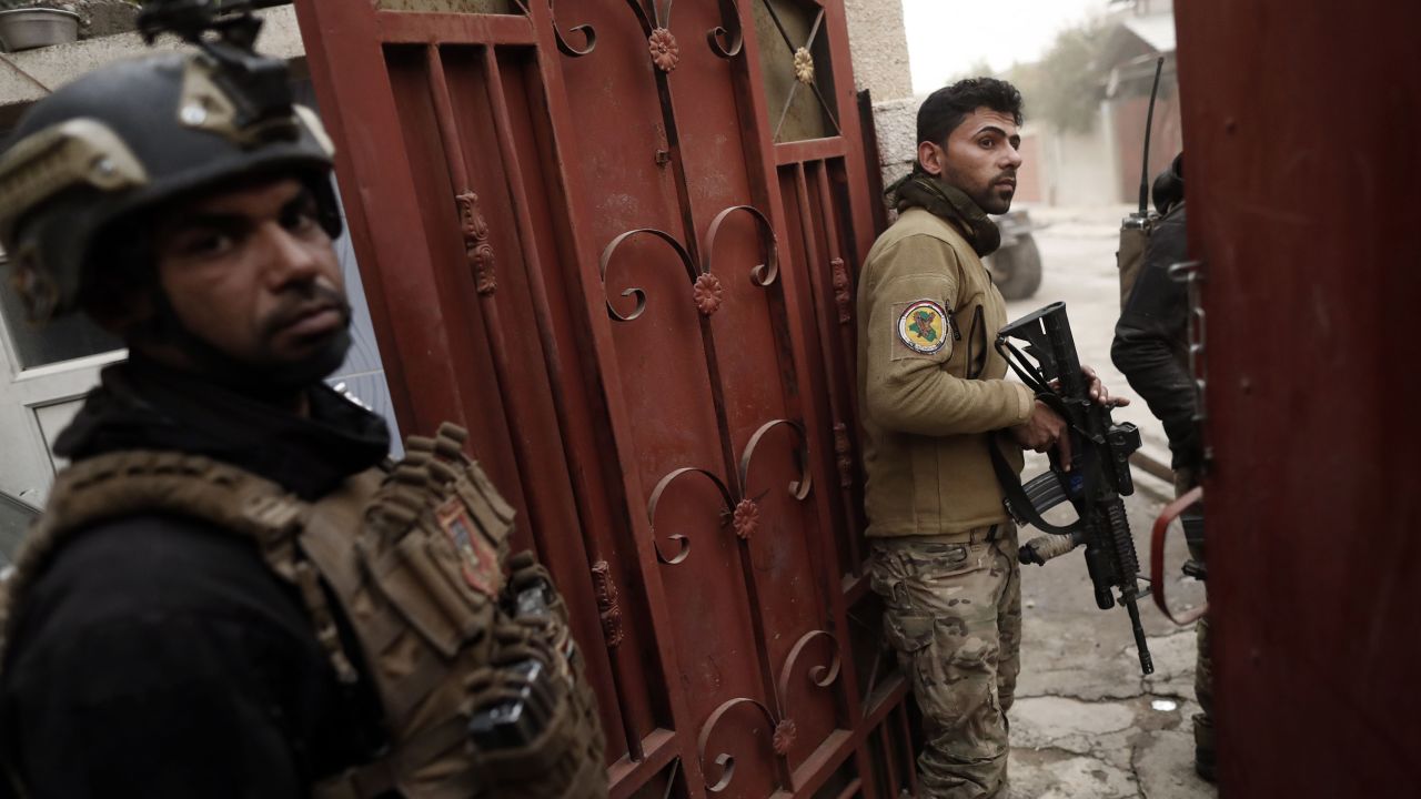 Members of the Iraqi Special Forces watch ongoing fighting from a house in an eastern district of Mosul on Friday.