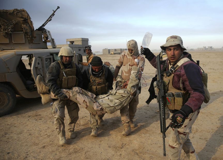 Iraqi soldiers transport a comrade who was injured during a battle near the village of Haj Ali on Tuesday, November 29.