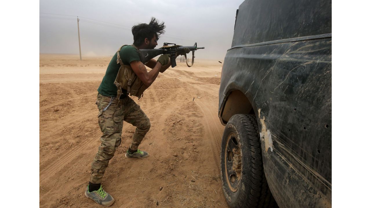 An Iraqi Shiite fighter from the Popular Mobilisation Units fires his weapon near the town of Tal Abtah, south of Tal Afar, on November 30.