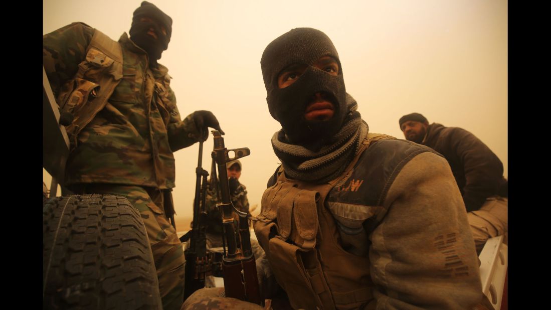 Iraqi Shiite fighters ride through a desert area near the village of Al-Boutha al-Sharqiyah, west of Mosul, on Friday, December 2.