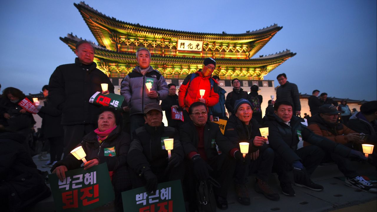 Protesters hold candles during a rally against South Korea's President Park Geun-hye in central Seoul on December 3. 