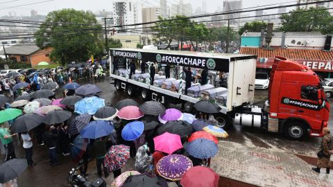 Despite heavy rainfall, people line the road to watch the passage of the funeral cortege in  Chapeco on December 3.