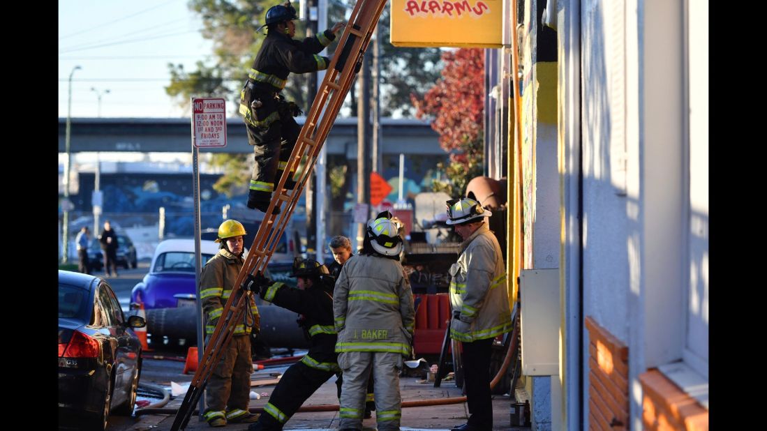 Firefighters begin to assess the scene of the warehouse fire on December 3.