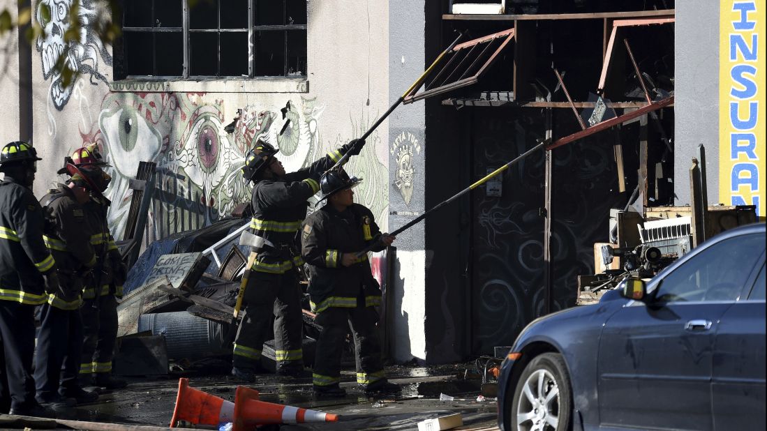 Firefighters clear an entry to the smoldering warehouse. 