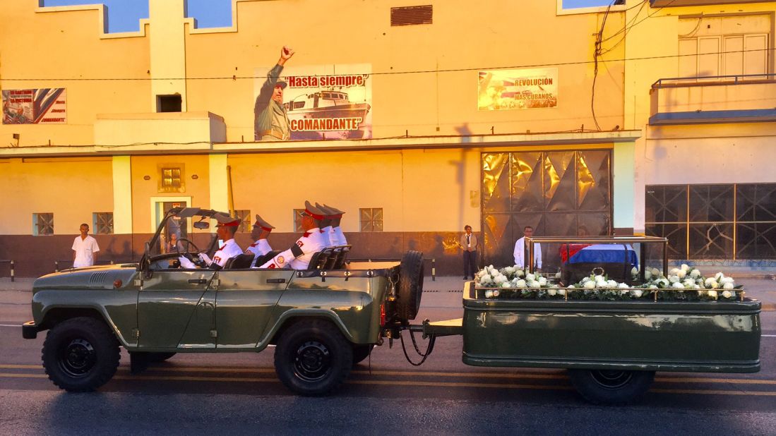 The ashes of the former Cuban leader pass below an iconic revolutionary banner as the cortège makes the final movement to the cemetery on December 4. 