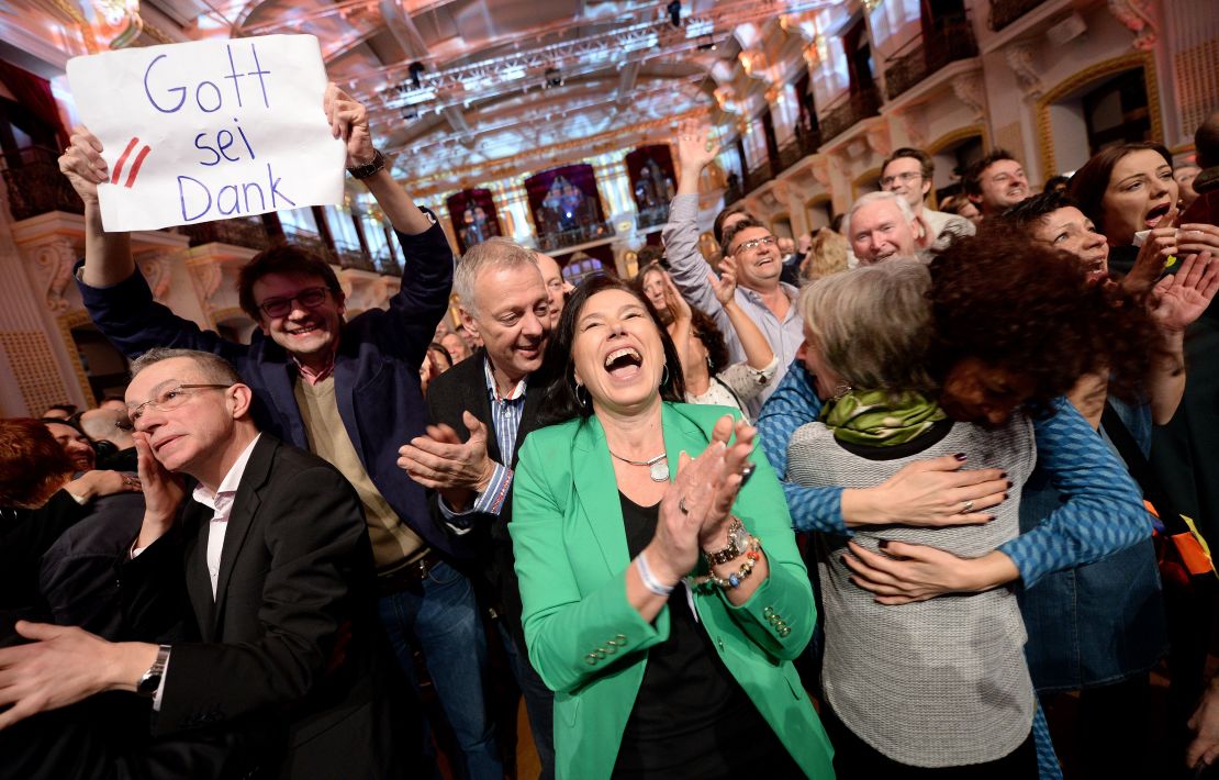 Alexander Van der Bellen supporters hold a sign readig "Thank God" as exit polls come in on Sunday.