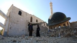 Kefa Jawish (R) and her husband Tajeddin Ahmed walk among the ruins of a destroyed mosque in Aleppo's Hanano district as they head to check their house for the first time in four years in the city's northeastern Haydariya neighbourhood on December 4, 2016.  

Jawish was among hundreds of Syrians returning to east Aleppo in recent days after the army recaptured large swathes of the city from rebels and encouraged residents to visit neighbourhoods and homes they left years earlier.

 / AFP / Youssef KARWASHAN / TO GO WITH AFP STORY BY RIM HADDAD        (Photo credit should read YOUSSEF KARWASHAN/AFP/Getty Images)