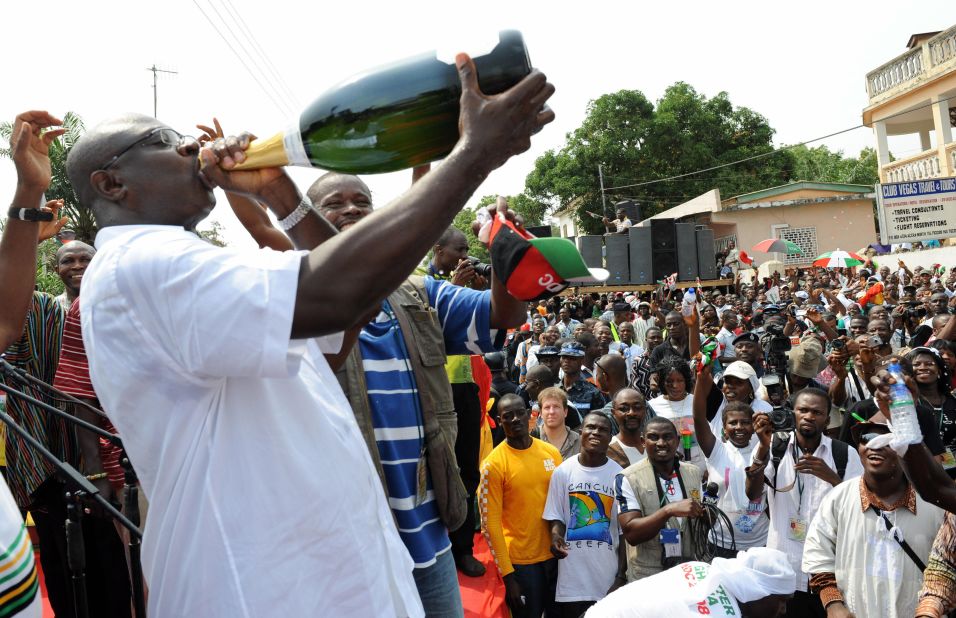 Supporters of National Democratic Congress (NDC) drink champagne and cheer to celebrate the election of President-elect John Attah Mills at his party headquarters in Accra on January 3, 2009.