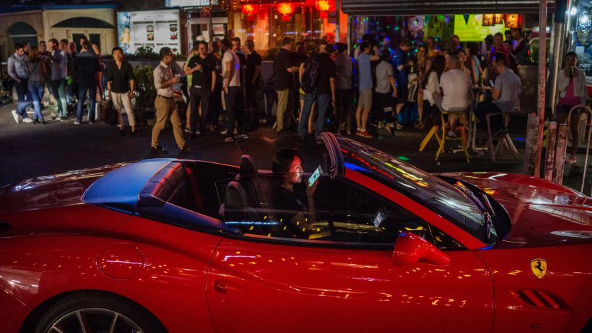 BEIJING, CHINA - MAY 30:  A Chinese woman talks on her mobile phone as she drives a luxury car throught a bar district on May 30, 2015 in Beijing, China. China is expected to become the world's largest luxury car market by 2016, analysts say. (Photo by Kevin Frayer/Getty Images)